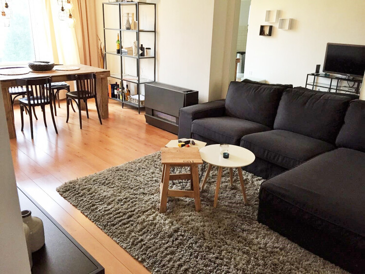 Spiegelwand achter de bank waardoor je tv ziet op de foto. Het maakt de woonkamer ruimtelijker