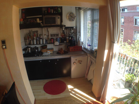 Keuken met gasstel, elektrische oven en magnetron en moderne ijskast.